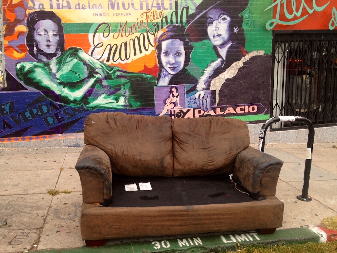 street couch in front of a mural